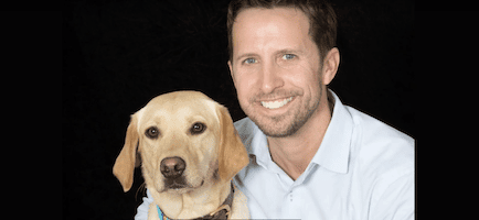 david adams posing with a golden retriever